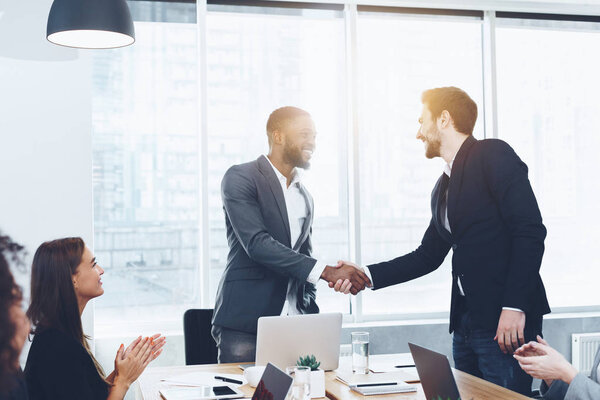 Welcome on board. Men shaking hands at office
