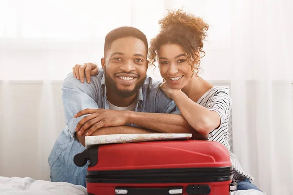 Szczęśliwa para, opierając się na walizkę, przygotowuje się do wakacji — Zdjęcie stockowe
