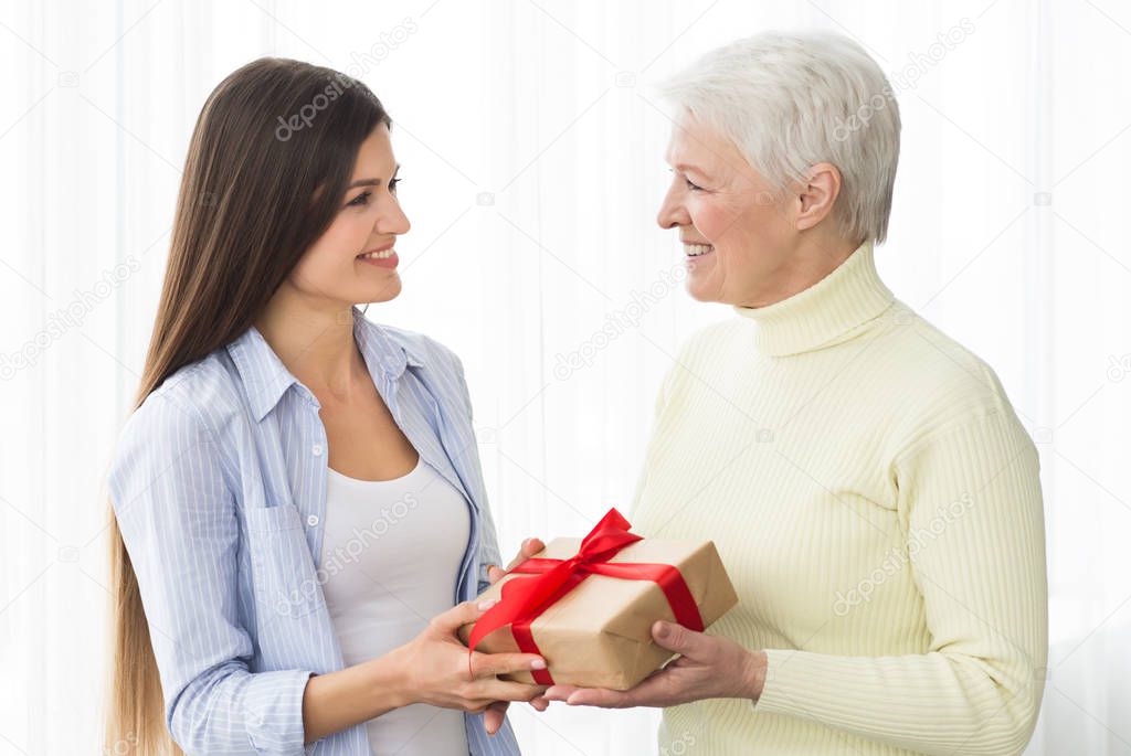 Senior mother receiving gift from adult daughter