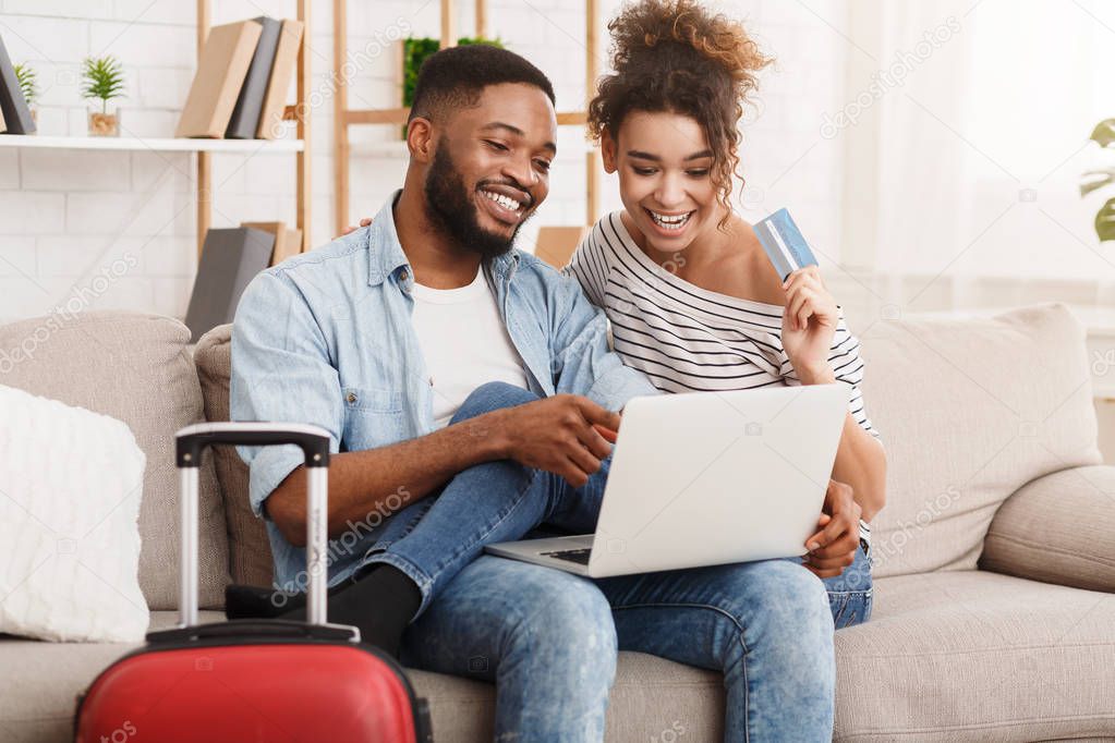 Romantic couple preparing for travel, using laptop