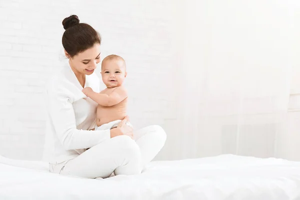 Jonge moeder haar schattige pasgeboren kind knuffelen — Stockfoto