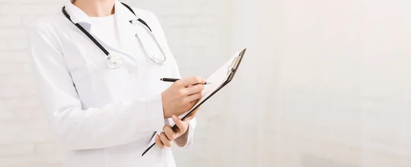 Female doctor filling up medical history of patient — Stock Photo, Image