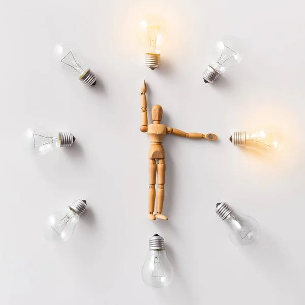 Maniquí de madera que lleva bombillas brillantes en blanco —  Fotos de Stock