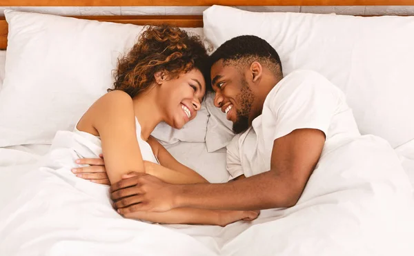 Draufsicht auf junges liebendes schwarzes Paar, das im Bett liegt — Stockfoto