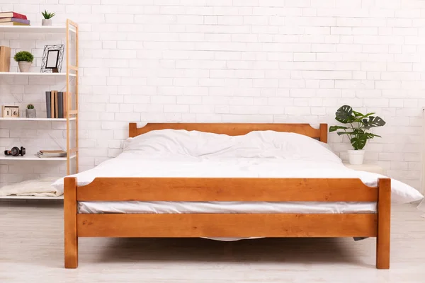 Wooden frame double bed with two pillows and blanket — стоковое фото