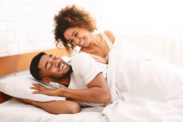 Gelukkige paar flirten in de ochtend op comfortabele bed — Stockfoto