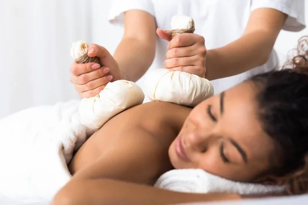 Mulher tendo massagem de compressa de ervas em spa de beleza — Fotografia de Stock