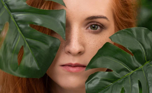 Portrait de jeune et belle femme aux feuilles tropicales — Photo