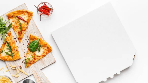 Pizzascheiben auf Schneidebrett und leerem Karton — Stockfoto