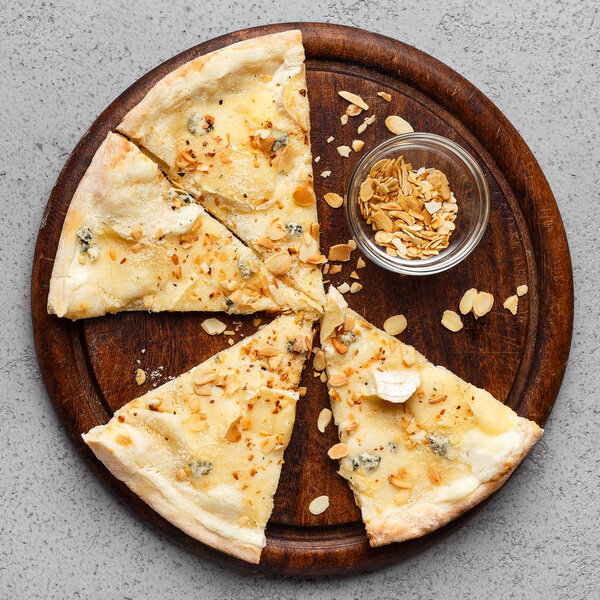 Slices of four cheese pizza on wooden board
