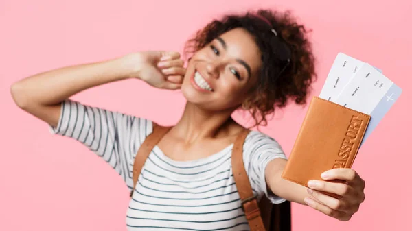 Mujer afroamericana mostrando pasaporte y boletos sobre fondo — Foto de Stock