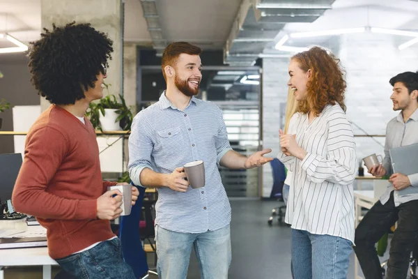 Compañeros alegres disfrutando de un descanso de café en la oficina —  Fotos de Stock