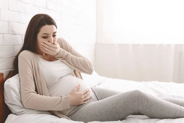 Gravid kvinna lider morgon illamående i sängen — Stockfoto