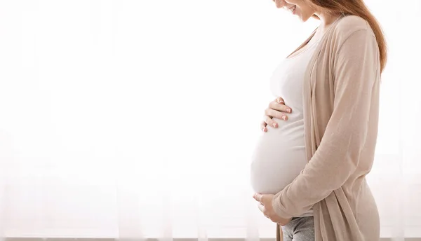 Piękne kobiety w ciąży, przytulanie jej brzuch w domu — Zdjęcie stockowe