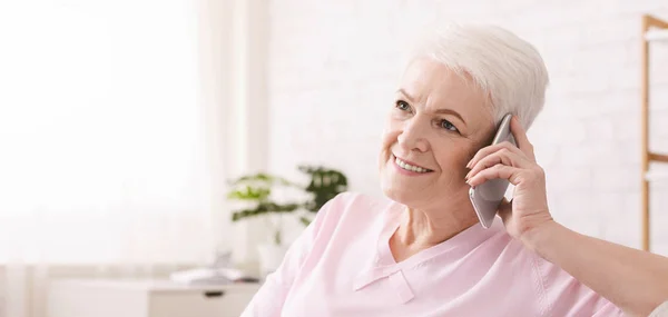 Seniorin telefoniert zu Hause mit ihrem Handy — Stockfoto