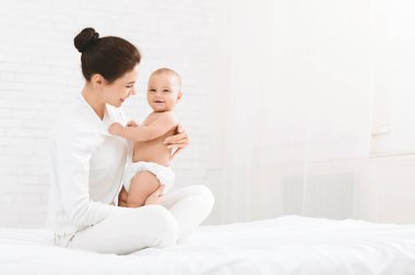 Genç Anne şirin yeni doğmuş çocuğunu sarılma