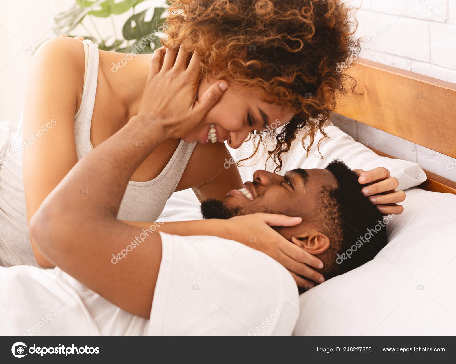 Happy black young couple kissing in bed Stock Photo by ©Milkos 248227856