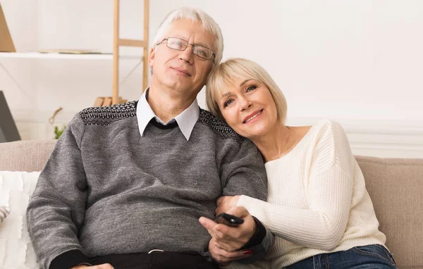 Liebendes Senioren-Paar vor dem Fernseher mit Fernbedienung — Stockfoto