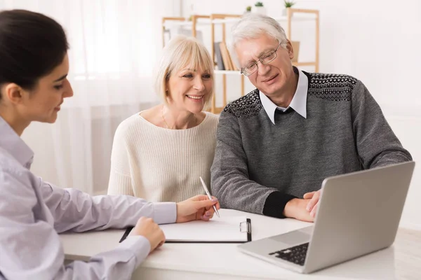 考虑新的家庭购买的老夫妇看笔记本电脑 — 图库照片