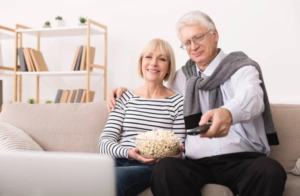 Senior paar televisie kijken en eten popcorn — Stockfoto