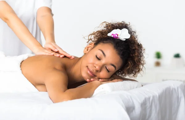Afroamerikansk flicka njuter ryggmassage i spasalong — Stockfoto