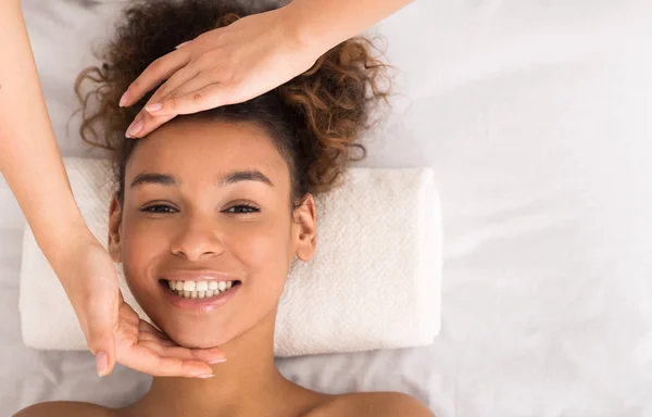 Afroamerikansk kvinna njuta av ansiktsmassage på skönhetssalong — Stockfoto
