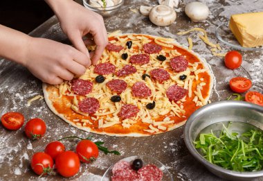 Pizza sanat. Şef çeşitli malzemelerle pizza dekorasyon