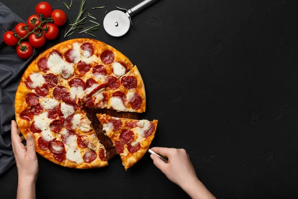 Frau nimmt Stück Pfefferoni-Pizza mit Spachtel — Stockfoto