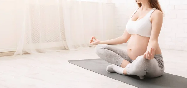 Pregnant woman meditating in lotus position at home — Stock Photo, Image