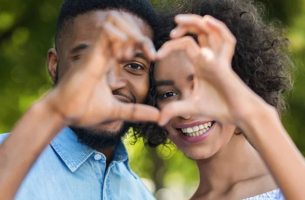 Cute couple making heart shape in park — Stock Photo, Image