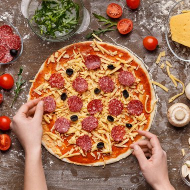 Salam pizzaya, üstten görünüm koyarak kadın