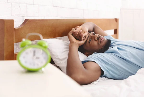 Homem negro na cama sofrendo de insônia e distúrbio do sono — Fotografia de Stock