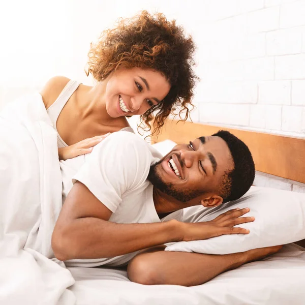 Gelukkige paar flirten in de ochtend op comfortabele bed — Stockfoto