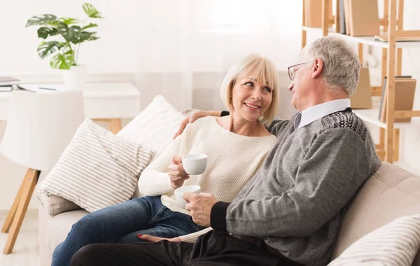 Relaxed senior couple drinking coffee, having rest