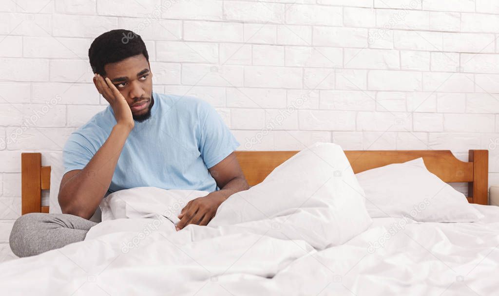 Thoughtful man considering breaking up with girlfriend in bed
