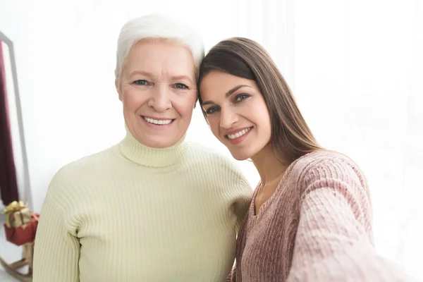 Senior mother and daughter taking selfie at home — Stock Photo, Image
