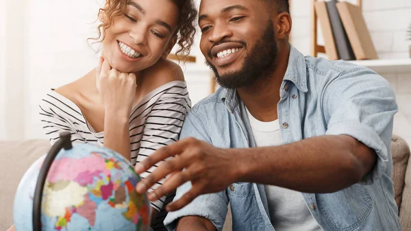 Glückliches Paar mit Weltkugel bei der Wahl des Reiseziels — Stockfoto