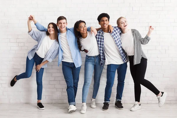 Fröhliche Teenager, die Spaß haben und über weiße Wände posieren — Stockfoto