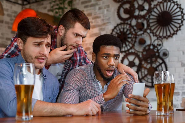 Amigos viendo fútbol en el smartphone en el bar — Foto de Stock