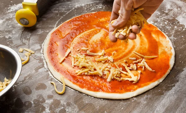 Ο άνθρωπος που προσθέτοντας τυρί για πίτσα στην κουζίνα — Φωτογραφία Αρχείου