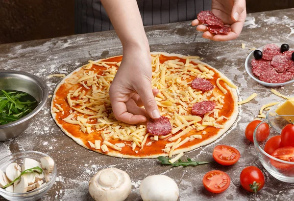 Koch bereitet italienische Pizza mit Salami zu, Nahaufnahme — Stockfoto