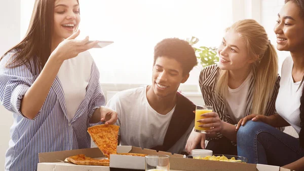 Joven blogger tomando fotos de pizza, teniendo una fiesta con amigos —  Fotos de Stock