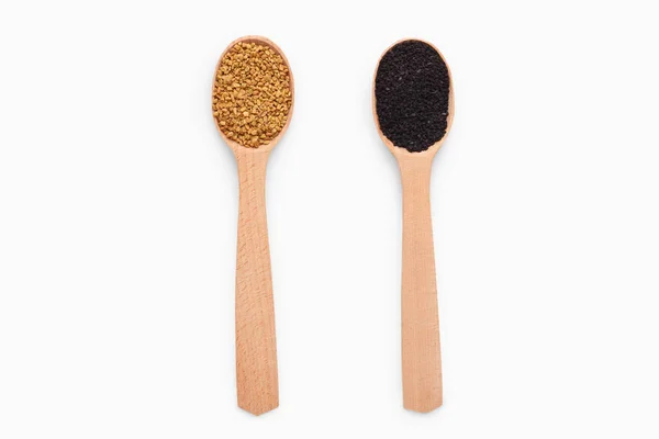 Wooden spoons with fenugreek and black sesame on white — Stock Photo, Image