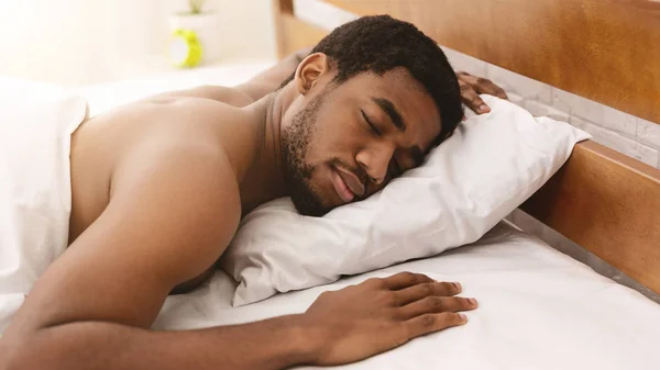 Hombre afroamericano desnudo durmiendo en la cama de cerca — Foto de Stock