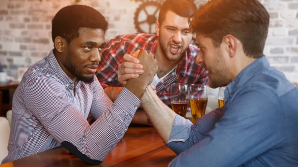 Друзья веселятся, дерутся друг с другом в баре — стоковое фото