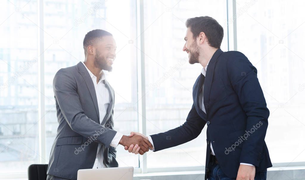 Business executives shaking hands, making successful deal