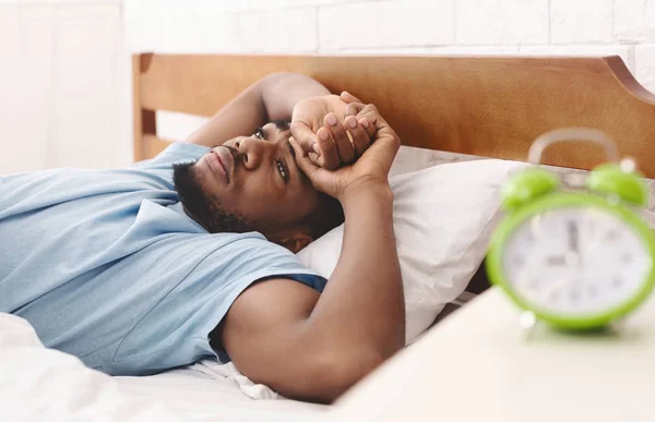 Homem negro na cama sofrendo de insônia e distúrbio do sono — Fotografia de Stock
