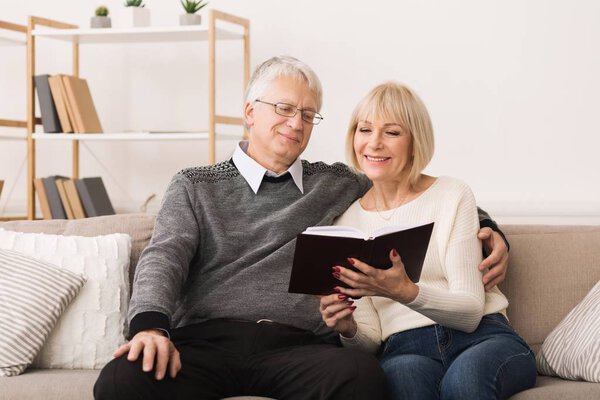 Happy mature couple having rest on couch at home