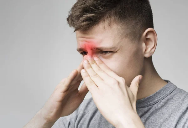 Üzgün adam çünkü burnunu tutarak sinüs ağrısı — Stok fotoğraf