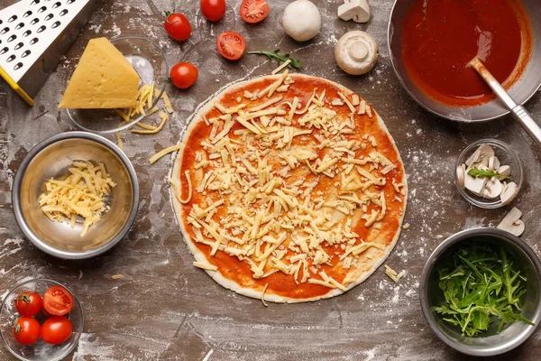 Unbaked πίτσα με τριμμένο τυρί και με συστατικά στη γύρω περιοχή — Φωτογραφία Αρχείου